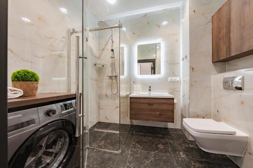 a bathroom with a washing machine and a sink at Sol Marina by Comfort Apartments in Wiślinka