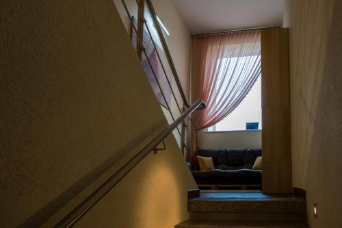 a staircase leading to a living room with a window at Agneta Apartamentai in Druskininkai
