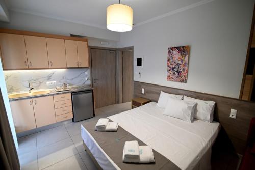 a bedroom with a large bed and a kitchen at SKYLINE Fine Living in Nei Poroi