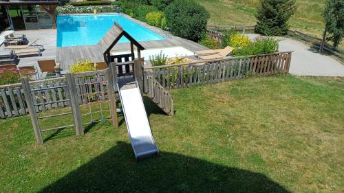 - un toboggan dans une cour à côté d'une piscine dans l'établissement Chalet Apartment Monêtier, au Monêtier-les-Bains
