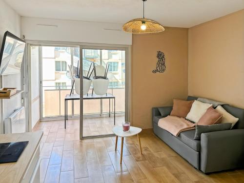 un salon avec un canapé et une table dans l'établissement Appartement cosy à Balaruc-les-Bains, à Balaruc-les-Bains