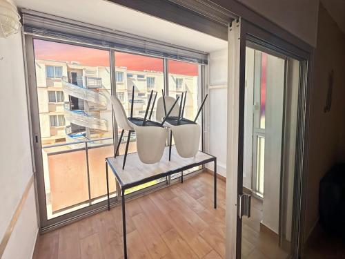 deux chaises assises sur une table devant une fenêtre dans l'établissement Appartement cosy à Balaruc-les-Bains, à Balaruc-les-Bains