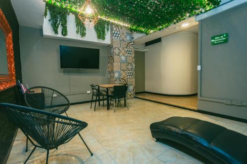 a room with a table and chairs and a tv at Mandala Hotel Belen in Medellín