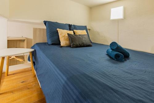 Cette chambre comprend un grand lit avec des draps et des oreillers bleus. dans l'établissement Studio GIGI 50 m mer climatisation plein centre, à Palavas-les-Flots