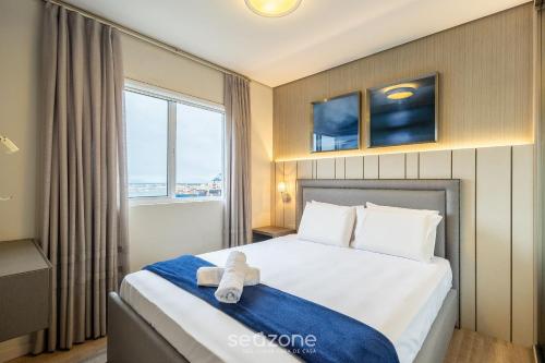 a hotel room with a bed with a teddy bear on it at Lindo Apartamento em Itajaí CTP1103 in Itajaí
