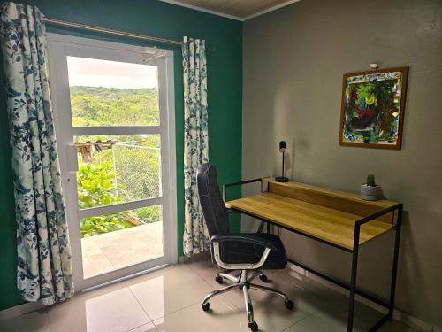 a desk and chair in a room with a window at Rio Sereno Haus mit Garten - Grenze zu Costa Rica in Río Sereno