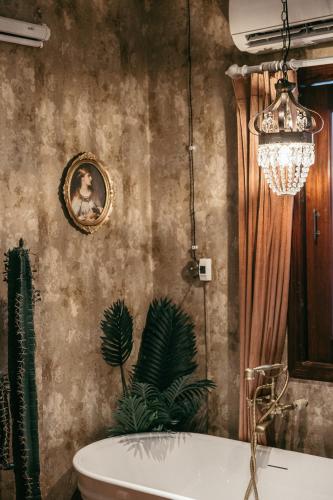 a bathroom with a tub and a picture on the wall at Mustang 11-11 Boutique Hotel Self Check In in Ho Chi Minh City