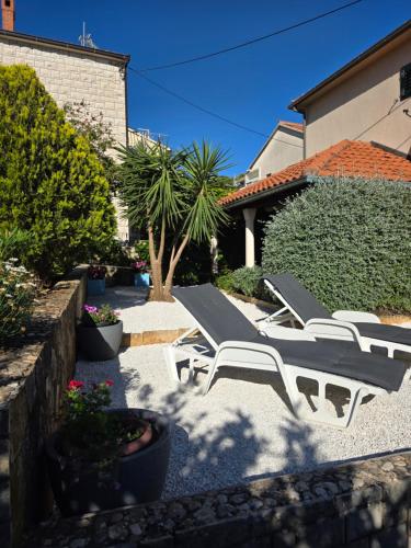 a group of lounge chairs sitting on a patio at Apartments Ita - Postira in Postira