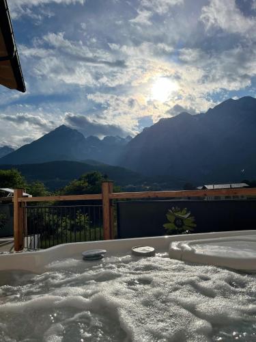 a jacuzzi tub with a view of mountains at Arnica Alpin Lodge in Cavedago