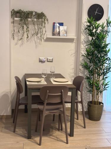 a dining room table and chairs with wine glasses at Cozy studio 700m from the Milan red metro in Sesto San Giovanni