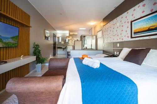 a hotel room with two beds and a kitchen at Pousada Natribus Rosa in Praia do Rosa