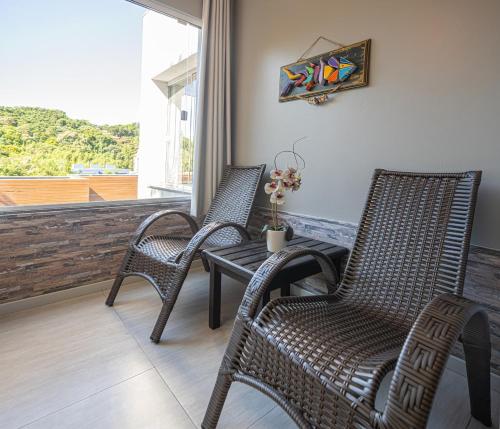 two chairs and a table on a balcony at Pousada Natribus Rosa in Praia do Rosa