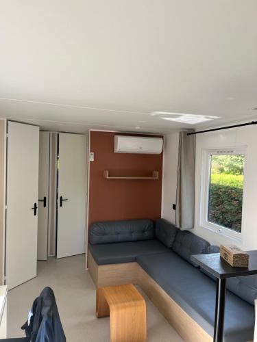 un salon avec un canapé et une fenêtre dans l'établissement Mobile-home premium azur Camping les vignes, à Lit-et-Mixe
