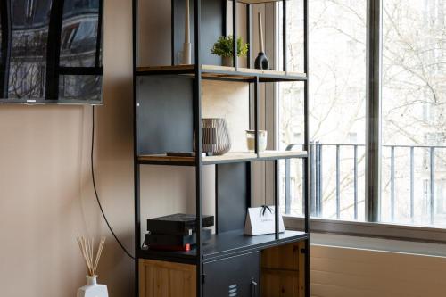 une étagère noire dans une chambre avec fenêtre dans l'établissement Charming Moulin Rouge Studio, à Paris