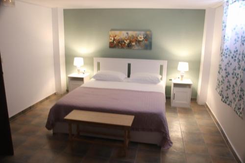 a bedroom with a bed with two night stands and two lamps at Villa Penelope Luxury Retreat with Pool & Timeless Charm in Douliana