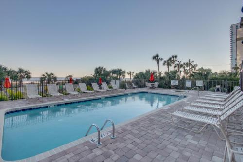 a swimming pool with lounge chairs at Oceanfront Condo with Balcony in Myrtle Beach
