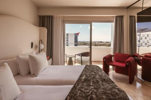 a hotel room with a bed and a large window at The Unexpected Ibiza Hotel - Ushuaïa Club entrance included in Playa d'en Bossa