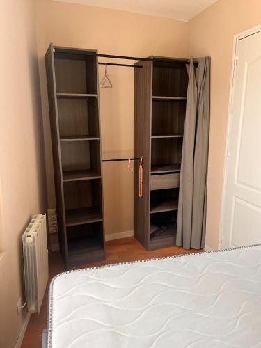 - une chambre avec un lit et un placard avec des étagères dans l'établissement Appartement à Dieppe, à Dieppe