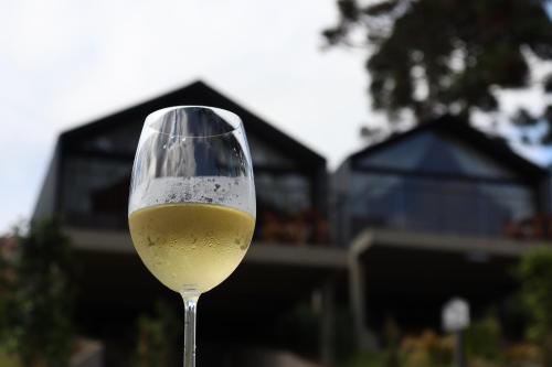 a glass of white wine in front of a house at Cappio Pousada e Lazer in Bento Gonçalves