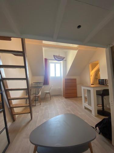- un salon avec une table et une échelle dans l'établissement STUDIO 22M2 Neuf CENTRE VILLE de NANTES à 100m de la Cathédrale, à Nantes