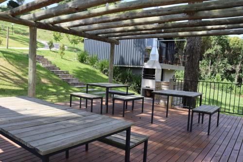 a group of picnic tables and benches on a deck at Cappio Pousada e Lazer in Bento Gonçalves