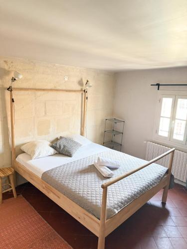 Un dormitorio con una cama grande con cabecero de madera. en Les chambres Saint-Roch, en Arles
