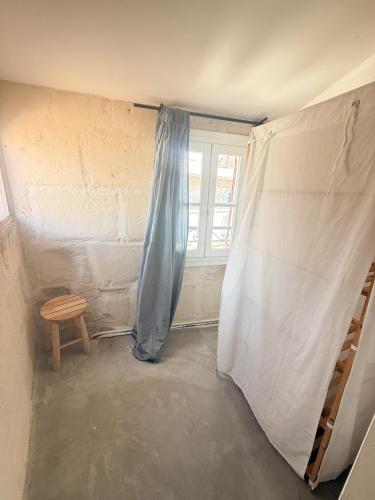 Habitación con ventana y cortina azul en Les chambres Saint-Roch, en Arles