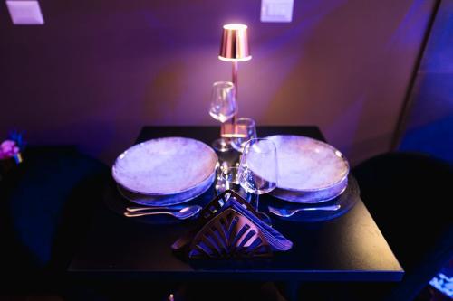 a table with wine glasses and a lamp on it at Tesse Suite in Canosa di Puglia