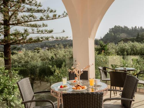 a table and chairs on a patio with a view at Hotel Varres in Zakynthos Town
