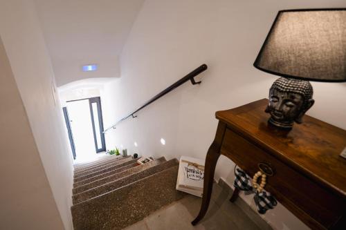 a room with a staircase with a lamp on a dresser at Tesse Suite in Canosa di Puglia
