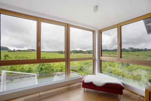 a room with large windows and a red bench at Ferienwohnung Auf Dem Haldershof in Wangen im Allgäu