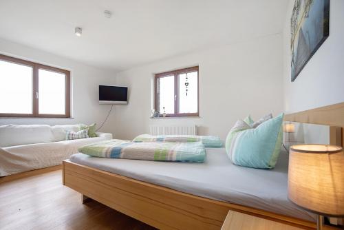a white room with a bed and a couch at Ferienwohnung Auf Dem Haldershof in Wangen im Allgäu