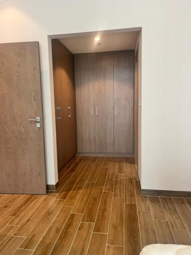 an empty room with wooden doors and wooden floors at EC Holiday Homes Dubai Al Furjan in Dubai