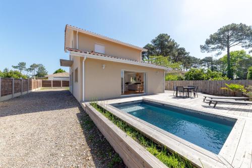 une maison avec une piscine dans l'arrière-cour dans l'établissement Villa Cazaline - Piscine Privée, à La Teste-de-Buch