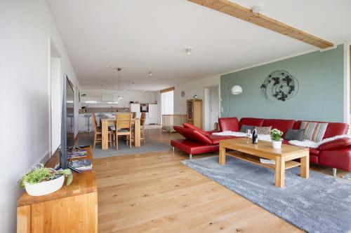 a living room with a red couch and a table at Ferienwohnung Auf Dem Haldershof in Wangen im Allgäu