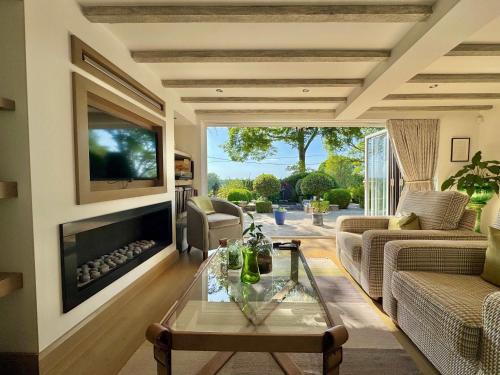 a living room with a fireplace and a tv at 2-Bed Cottage Garden Views near the Peak District in Macclesfield