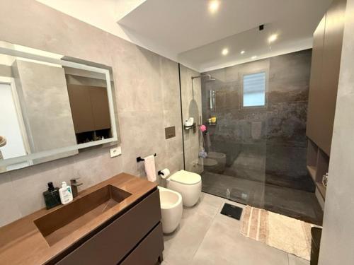 Un baño con lavabo, inodoro y ducha. en Villa Ginevra, en Otranto