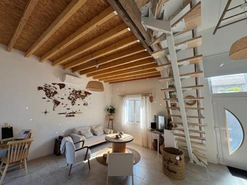 a living room with a couch and a spiral staircase at Le Gite de l Ancre in Ville-sur-Ancre