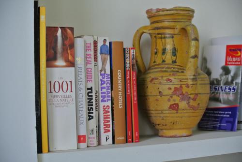 a book shelf with a vase and books at Dar Ben Gacem in Tunis