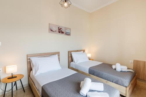 a bedroom with two beds and a table with a stool at Christina's apartment in Kontokali