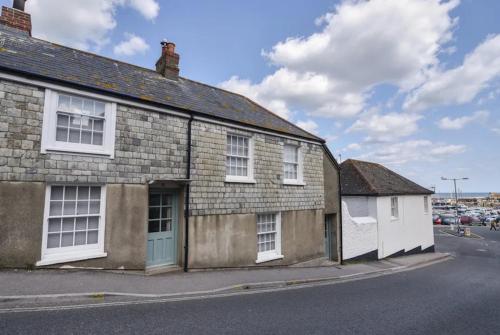 an old brick building with a blue door on a street at Stay at No12 in Lyme Regis