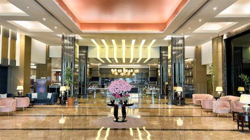 a lobby with pink flowers in the middle of a building at Radisson Blu Hotel Rudrapur in Rudrapur