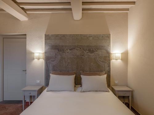 a bedroom with a large white bed with two tables at Resort Casale Le Torri in Ponsacco