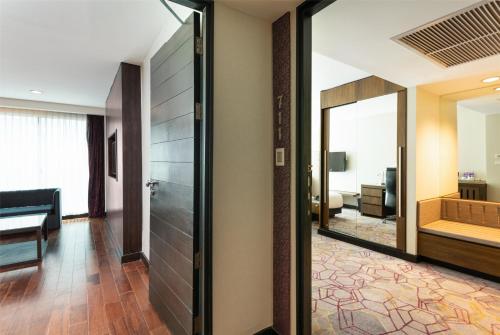 a hallway with a mirror and a living room at Radisson Suites Bangkok Sukhumvit in Bangkok