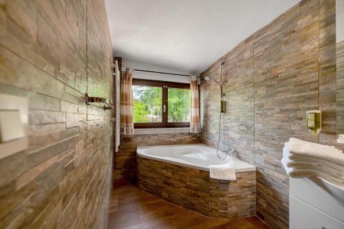 a bathroom with a bath tub and a window at Bed and Breakfast St Wendel in Prüm