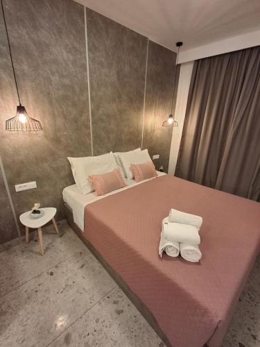 a bedroom with a large bed with two towels on it at Peter's Place Studios & Suites in Faliraki