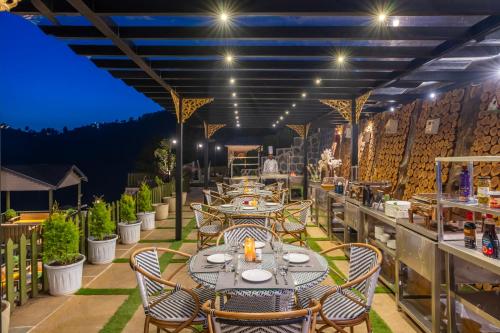a restaurant with tables and chairs on a patio at The English Country House in Mussoorie