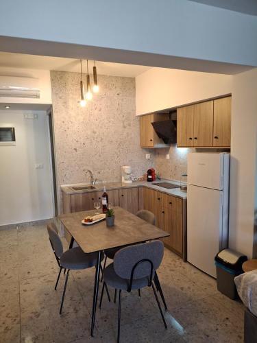 a kitchen with a table and chairs and a refrigerator at Peter's Place Studios & Suites in Faliraki