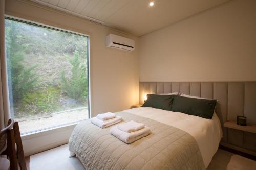 a bedroom with a bed with towels on it at The Fox by LovelyStay in Sobral de Monte Agraço