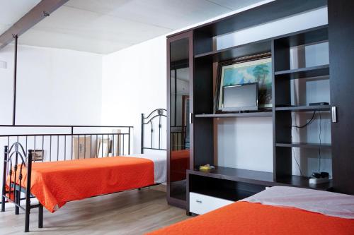 a bedroom with an orange bed and a black book shelf at Casa Vacanze San Pietro in Canosa di Puglia